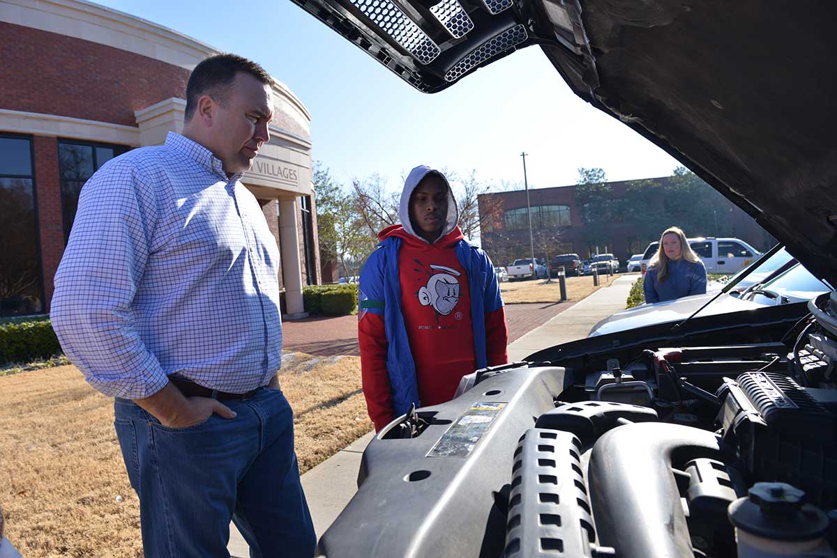 Laxavier and John looking under the hood