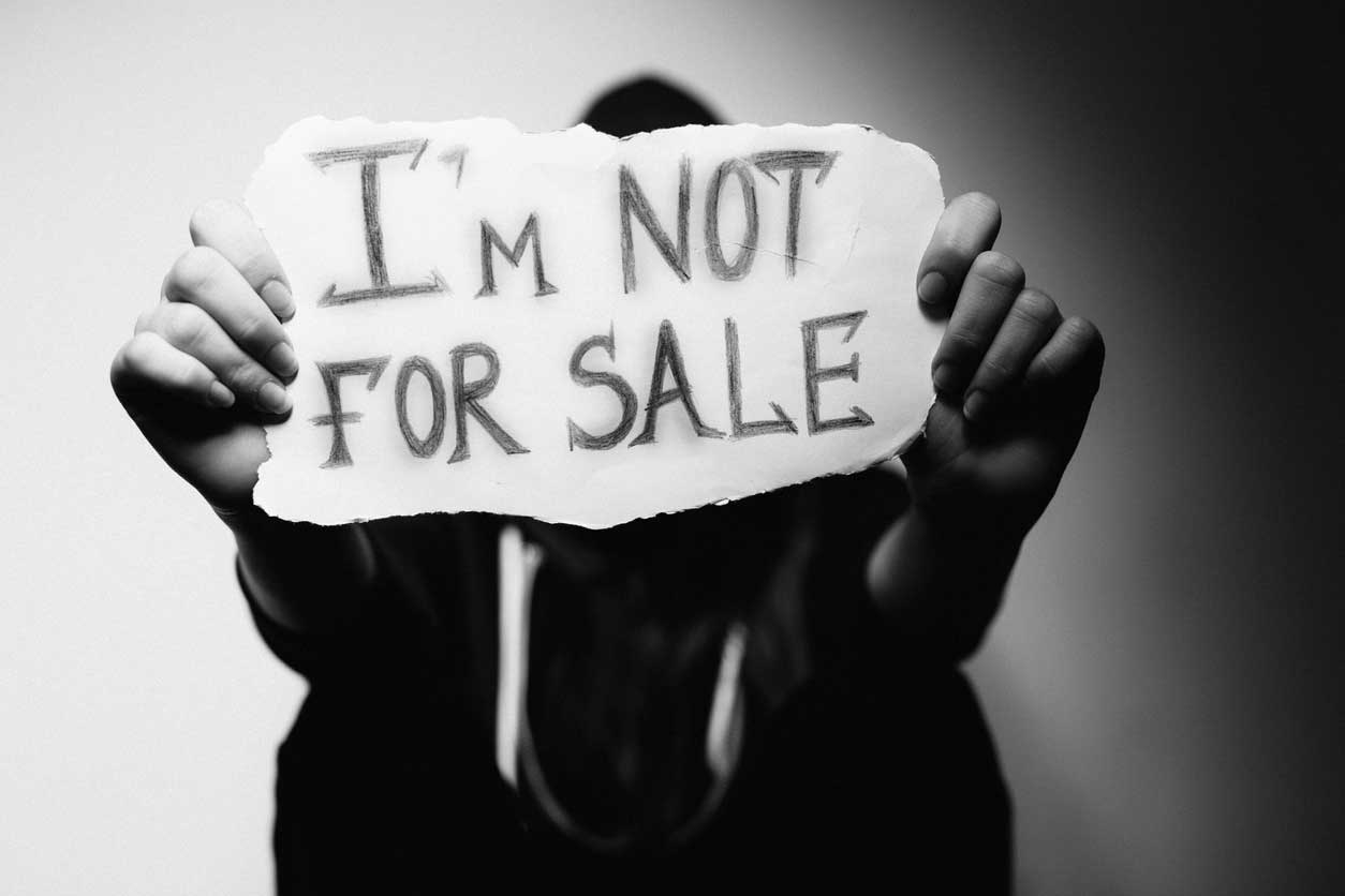 woman holding "I'm not for sale" sign