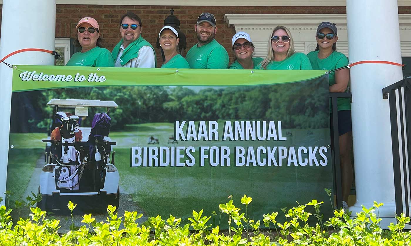 Golf tournament participants with Knoxville Area Association of Realtors banner
