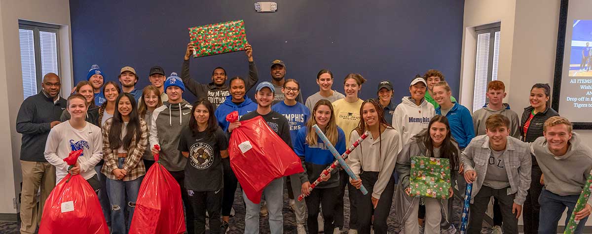 University of Memphis Athletics wrapping presents for Holiday Heroes