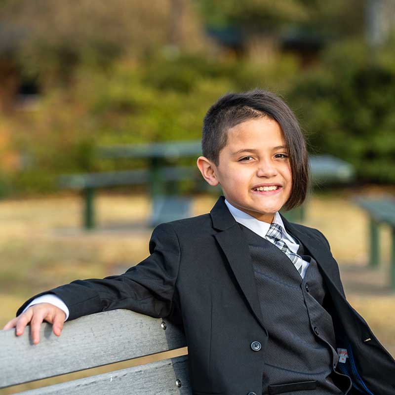 Alejandro sitting on bench smiling