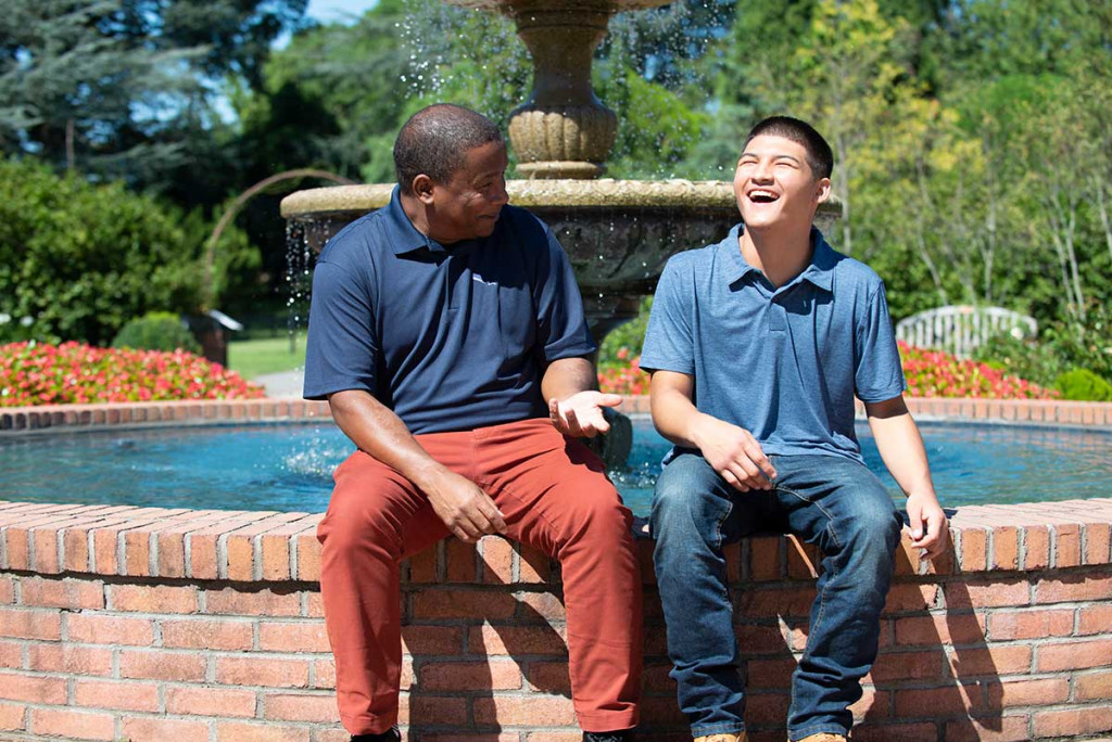 Mentee and Mentor, Michael and Patrick sitting in front of water fountain