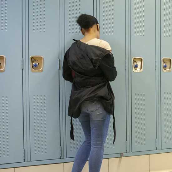 A student at her locker in a hallway at North-Grand High School in Chicago. Dropout rates have gone up in some areas amid COVID.
