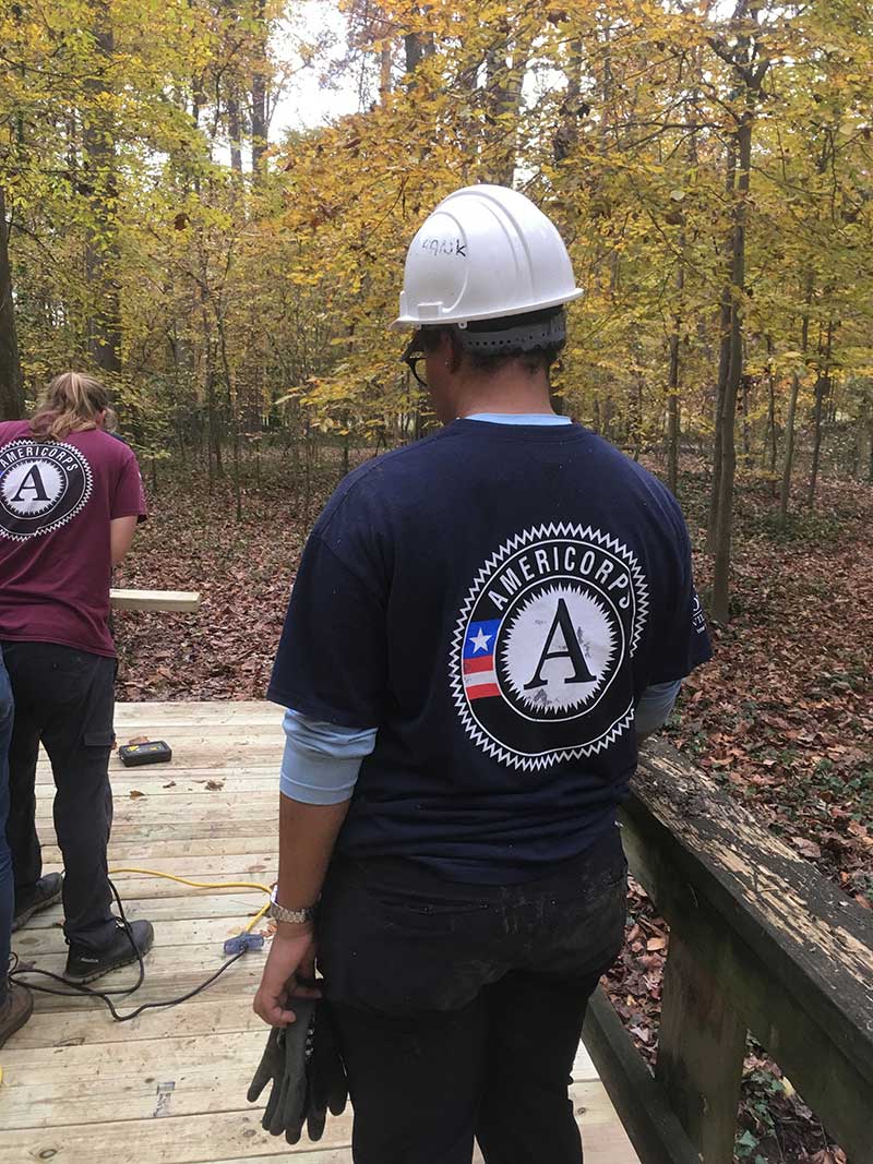 AmeriCorps staff help build a bridge on the Inner Harbour Campus