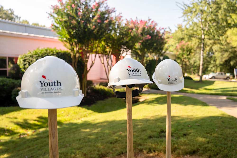 Youth Villages hard hats sitting on top of shovels sticking up from the ground