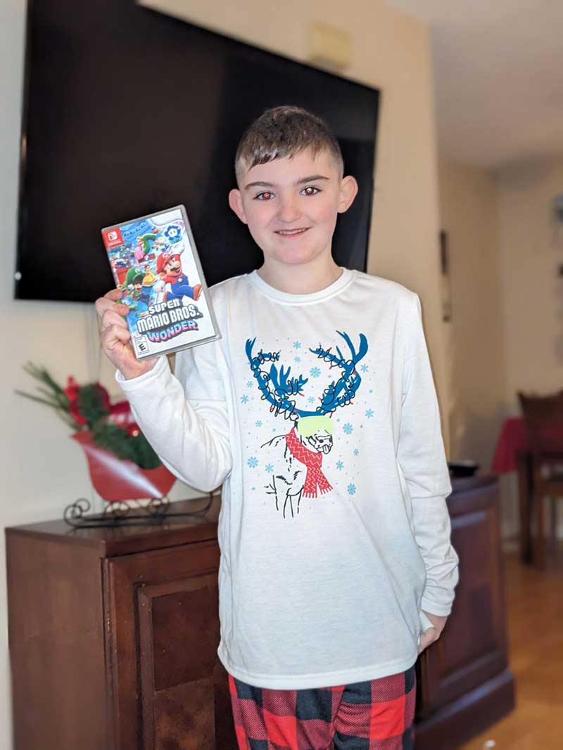 male youth with video game gift from Holiday Heroes