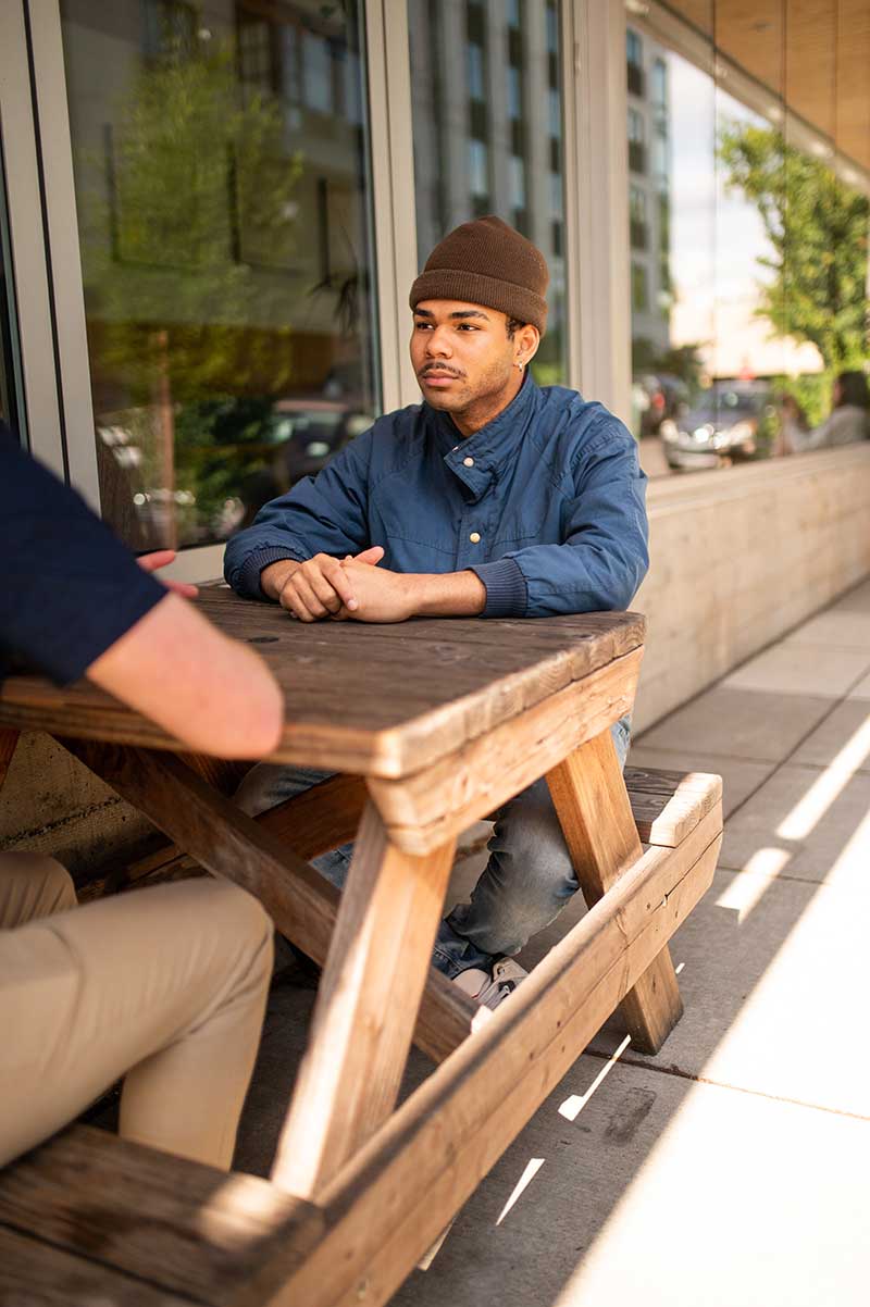 LifeSet participant sitting down on a bench with his specialist