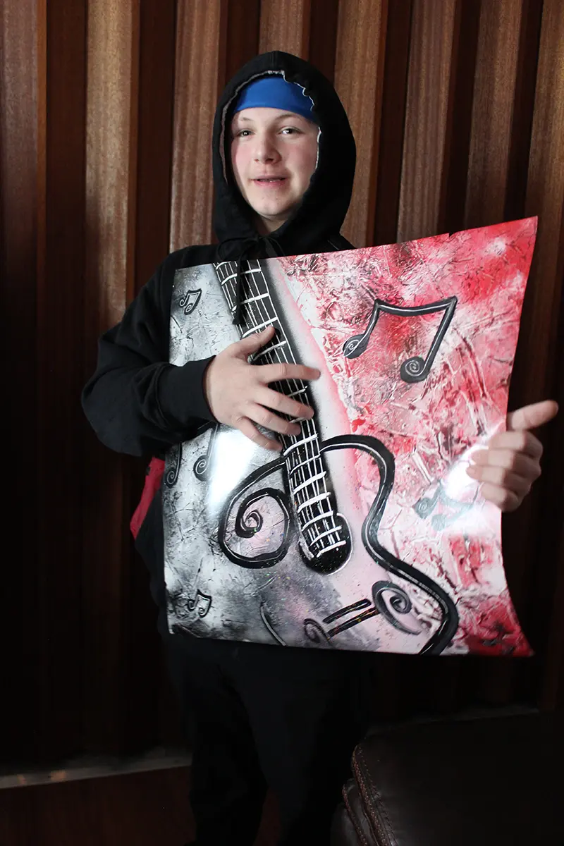 Jay holding a guitar poster