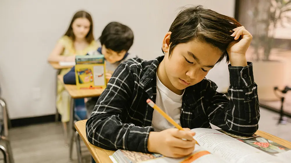 young kid in class writing