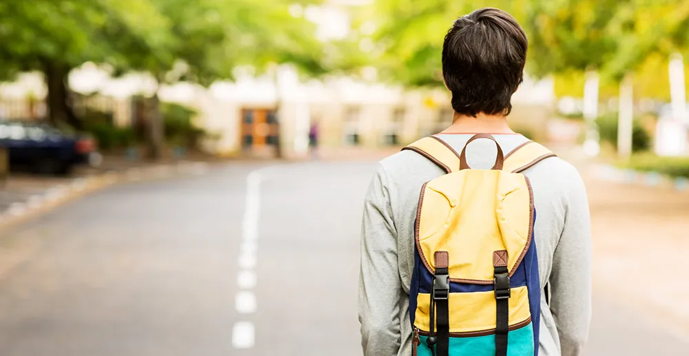 young man walking with backpack