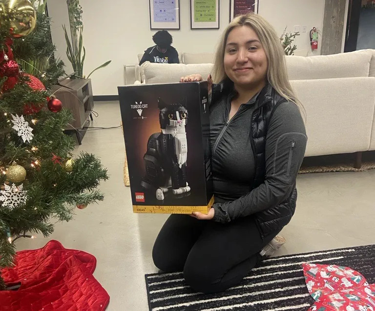 Youth Villages Scholar, Natalie, opening Holiday Heroes gift